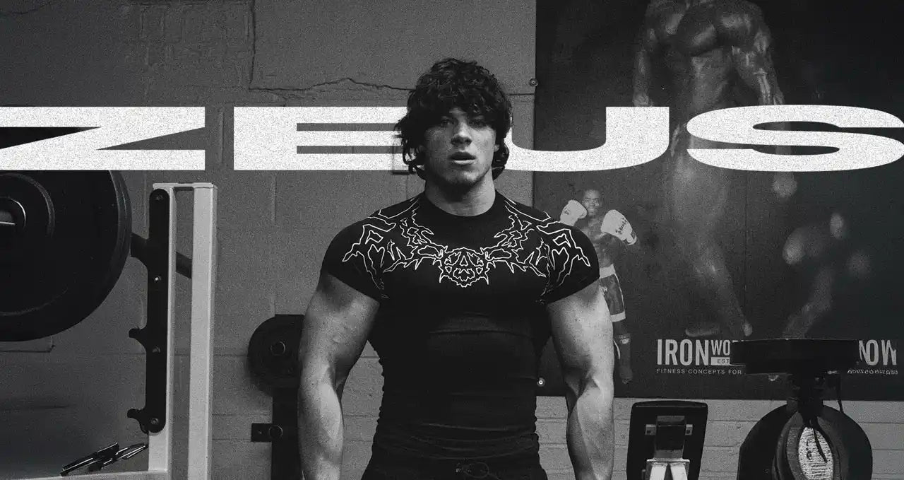A muscular man in a gym wearing a black t-shirt with a tribal design.